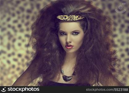 pretty young girl with creative curly hair-style posing with sexy make-up and leopard accessory in the hair and necklace