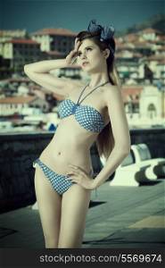 pretty young girl with long blonde hair and vintage foulard in the hair in fashion pose with lovely swimwear