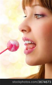 Pretty young girl with sugar lips licking a lollipop