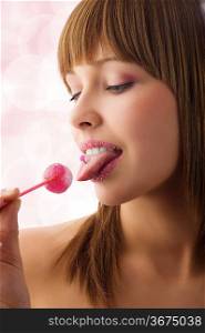 Pretty young girl with sugar lips licking a pink lollipop