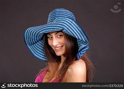 Pretty young smiling girl in hat on dark background
