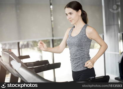 Pretty young sport woman is running on treadmill in gym, Healthy lifestyle