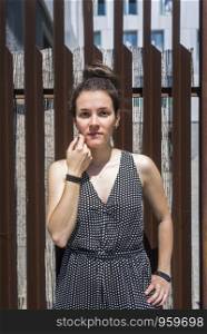 Pretty young stylish woman standing at fence. Erica Vilaro.jpg