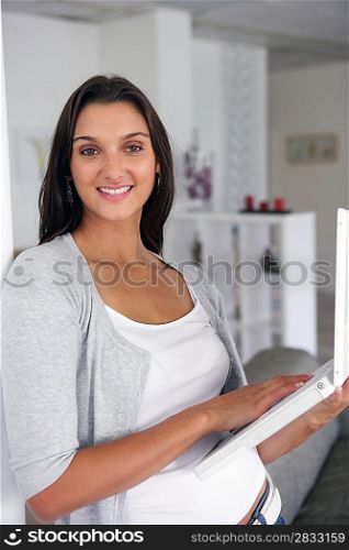 Pretty young woman at home with laptop