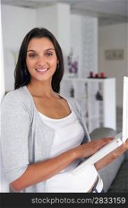 Pretty young woman at home with laptop