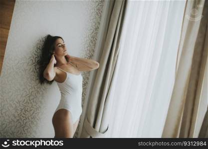 Pretty young woman by the window in the room