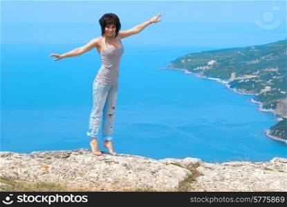 Pretty young woman dancing on the rock