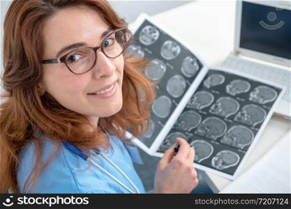 pretty young woman doctor looking at an x-ray in an office