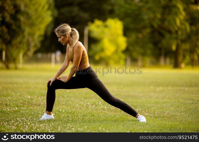 Pretty young woman doing stretching in the park