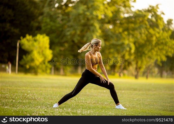 Pretty young woman doing stretching in the park