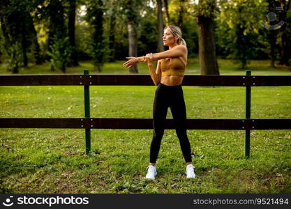 Pretty young woman doing stretching in the park