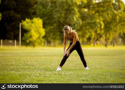 Pretty young woman doing stretching in the park