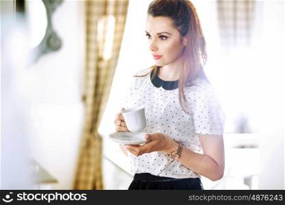 Pretty young woman drinking coffee