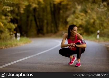 Pretty young woman have a break during training in the autumn forest