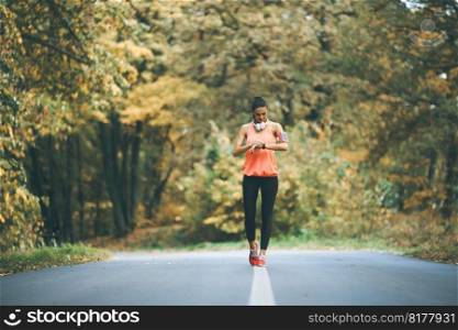 Pretty young woman have a break during training in the autumn forest