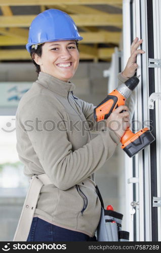 pretty young woman holding cordless drill
