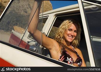Pretty Young Woman in Car at Beach