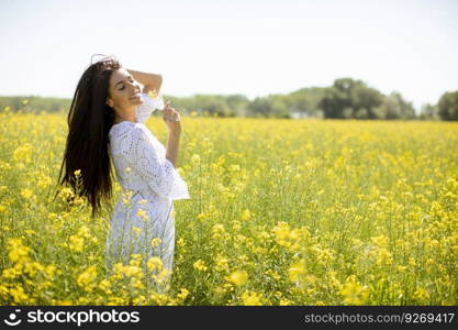 Pretty young woman in the rapeseed field