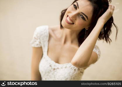 Pretty young woman in white dress on the street