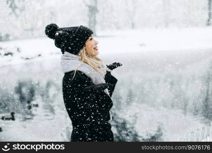 Pretty young woman n warm clothes enjoying in snow