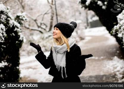 Pretty young woman n warm clothes enjoying in snow