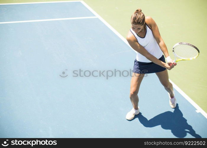 Pretty young woman playing tennis on a sunny day