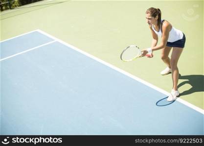 Pretty young woman playing tennis on a sunny day