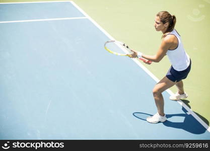 Pretty young woman playing tennis on a sunny day