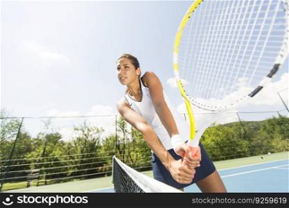 Pretty young woman playing tennis on a sunny day