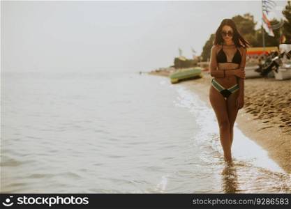 Pretty young woman posing on the beach in a bikini