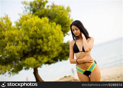Pretty young woman posing on the beach in a bikini