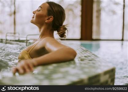 Pretty young woman relaxing in the whirlpool bathtub at the poolside