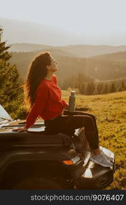 Pretty young woman relaxing on a terrain vehicle hood at countryside