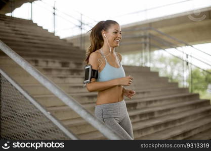 Pretty young woman running alone down stairs outdoor in urban environment