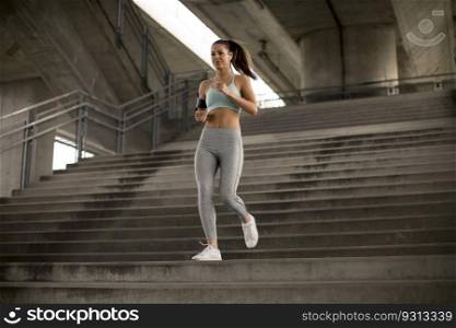 Pretty young woman running alone down stairs outdoor in urban environment