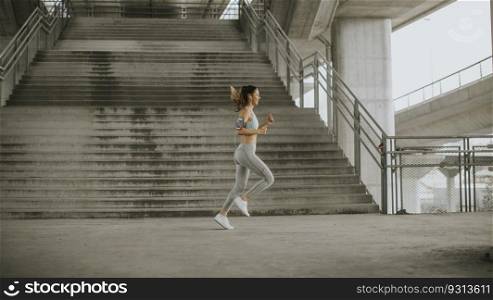 Pretty young woman running in the urban environment