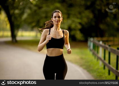 Pretty young woman running on a lane in the park