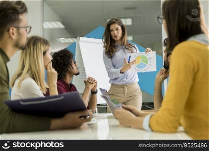 Pretty young woman showing paper chart to young workers at small startup company