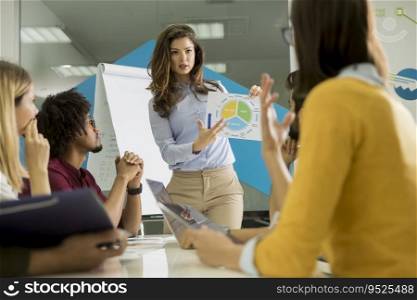 Pretty young woman showing paper chart to young workers at small startup company