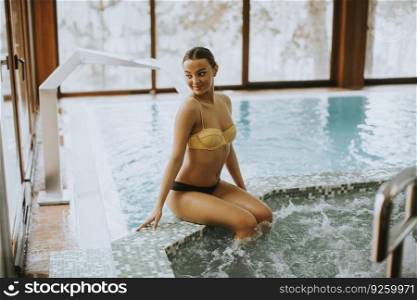 Pretty young woman sitting and relaxing by the whirlpool bathtub