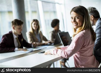 Pretty young woman smiling during successful business meeting in the modern office
