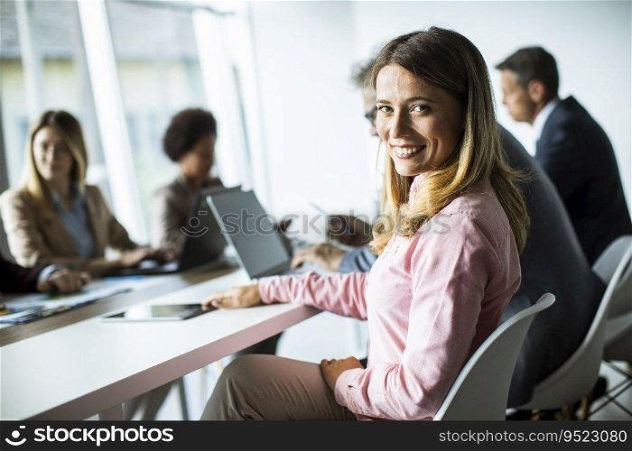 Pretty young woman smiling during successful business meeting in the modern office
