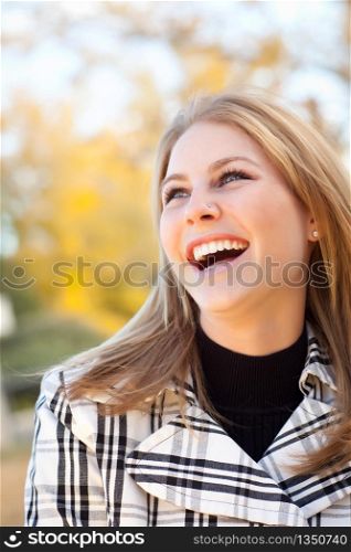 Pretty Young Woman Smiling in the Park on a Fall Day.