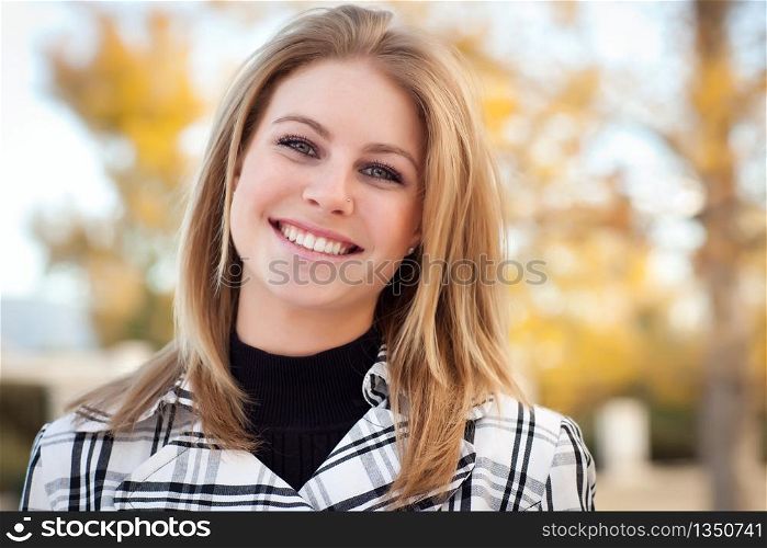 Pretty Young Woman Smiling in the Park on a Fall Day.