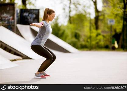 Pretty young woman stretching in the park