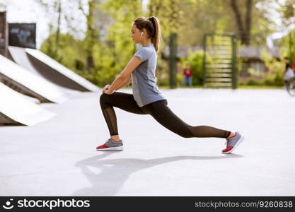 Pretty young woman stretching in the park