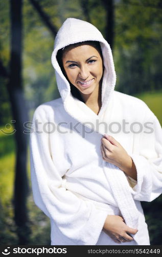 Pretty Young woman take a steam bath treatment at finish wooden sauna while wearing white towel