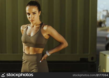 Pretty young woman takes a break after running in the urban area