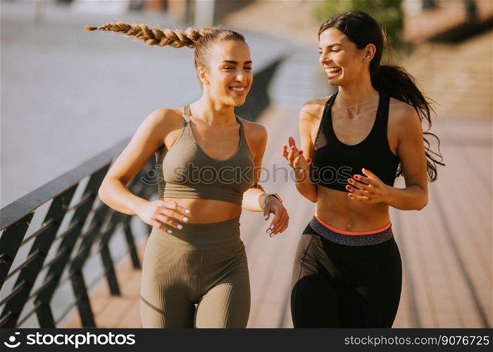 Pretty young woman taking running exercise by the river promenade