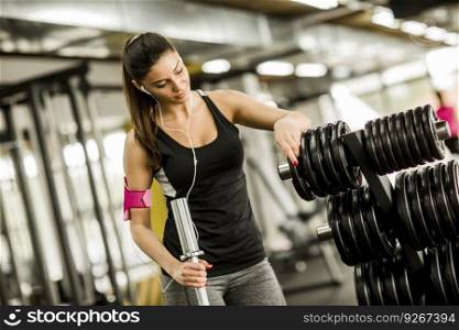Pretty young woman training with weight equipment in the gym